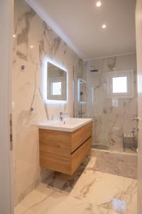 uma casa de banho com um lavatório, um chuveiro e uma banheira em Karlovasi Comfy Retreat em Ríva