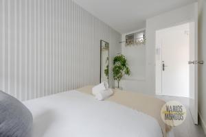 a white bedroom with a large bed and a window at Atico Calle Silva para 3pax con terraza esquina con Gran Via in Madrid
