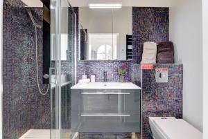 Un baño con lavabo y ducha de cristal. en Cocoon in Cannes Sea View., en Cannes 28 fotos más