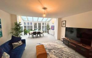 a living room with a blue couch and a table at High Wycombe Stunning Stylish Four Bedroom House in High Wycombe
