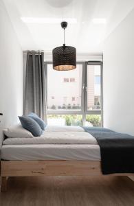 a bedroom with a large bed and a window at Scala Apartamenty by Moderna Profit- Łąkowa 60K in Gdańsk