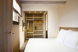 1 dormitorio con cama blanca y armario en Barcelona Apartment Milà en Barcelona