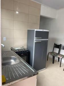 a kitchen with a stainless steel refrigerator and a sink at Pousada da Vovó Ideni Nova Tramandaí in Tramandaí