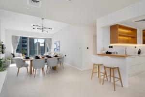 a white kitchen and dining room with a table and chairs at Lavish Living in Dubai Marina's Finest 2 bedroom in Dubai