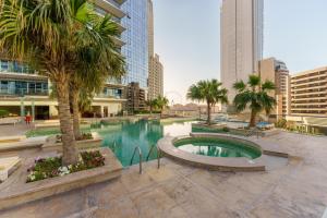 a pool in a city with palm trees and buildings at Lavish Living in Dubai Marina's Finest 2 bedroom in Dubai