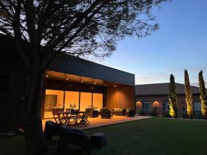 une maison avec une cour dotée d'une table et de chaises dans l'établissement Hôtel & Séminaire Le Patio Occitan - Toulouse Ouest - Francazal, à Cugnaux