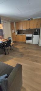 ein leeres Wohnzimmer mit einem Tisch und einer Küche in der Unterkunft Stuga utanför Skövde 3 in Skövde