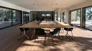 une grande salle de conférence avec une grande table et des chaises dans l'établissement Hôtel & Séminaire Le Patio Occitan - Toulouse Ouest - Francazal, à Cugnaux