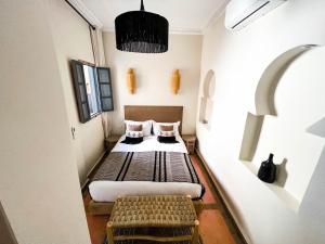 Cette petite chambre comprend deux lits et deux bancs. dans l'établissement Riad Jonan & Spa, à Marrakech