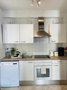 a kitchen with white cabinets and a sink at Pimms Apartment in Antibes