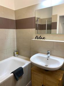 een badkamer met een wastafel, een bad en een spiegel bij SECRET HIDEAWAYS Design Apartment ARTstudio 5 nahe City l Messe l Hbf in Duisburg