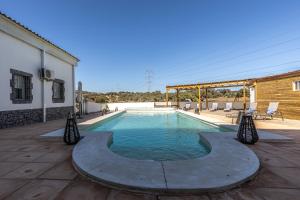 einen Pool auf einer Terrasse neben einem Gebäude in der Unterkunft Hotel Rural Ganadería Virgen María in Sevilla