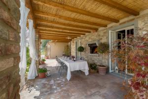 eine Terrasse mit einem Tisch und Stühlen darauf in der Unterkunft Casale La Rugantina in Cortona