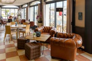 a restaurant with leather furniture and tables and chairs at Abrivado in Saintes-Maries-de-la-Mer