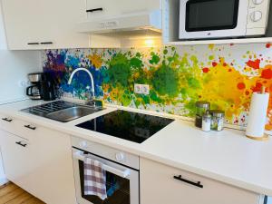 een keuken met een spoelbak en een magnetron bij SECRET HIDEAWAYS Design Apartment ARTstudio 5 nahe City l Messe l Hbf in Duisburg