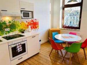 een keuken met een tafel en een tafel met stoelen bij SECRET HIDEAWAYS Design Apartment ARTstudio 5 nahe City l Messe l Hbf in Duisburg