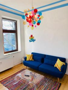 sala de estar con sofá azul y lámpara de araña en SECRET HIDEAWAYS Design Apartment ARTstudio 5 nahe City l Messe l Hbf, en Duisburg