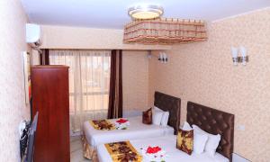 a hotel room with two beds and a window at Easy Hotel Kenya in Nairobi