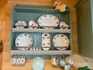 un estante lleno de platos y tazas en Chalet Alma en Haus im Ennstal
