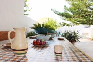 a table with a vase and a bowl of fruit on it at Llevantada - Casa en Poblenou del Delta con piscina privada y barbacoa in El Poblenou del Delta