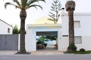 deux palmiers devant un bâtiment dans l'établissement Llevantada - Casa en Poblenou del Delta con piscina privada y barbacoa, à El Poble Nou del Delta