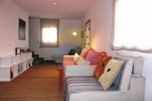 a living room with a white couch with colorful pillows at Llevantada - Casa en Poblenou del Delta con piscina privada y barbacoa in Poblenou del Delta