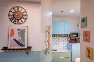 a kitchen with a clock on the wall and a refrigerator at La salle Avenue Condo Residences in Bacolod