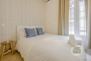 a bedroom with a large white bed with blue pillows at Centrico and Cozy Apt para 9pax en Calle San Dimas in Madrid