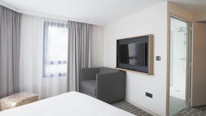 ein Hotelzimmer mit einem Bett und einem TV in der Unterkunft ibis Styles Laval Centre Gare in Laval