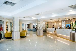 a lobby of a hotel with tables and chairs at Hôtel La Solitude in Lourdes