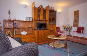 ein Wohnzimmer mit einem Sofa und einem TV in der Unterkunft D10 - Ferragudo Townhouse in Ferragudo
