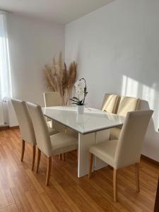 een eettafel en stoelen met een witte tafel bij Appartement des 3 frontières in Saint-Louis