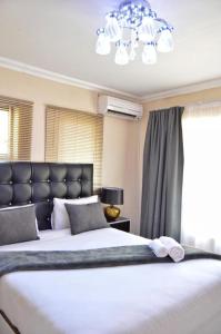 Un dormitorio con una cama grande y una lámpara de araña. en Dineo's Lodge and Spa, en Burgersfort