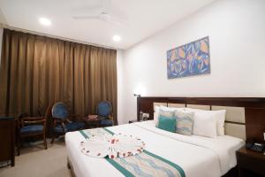 Horizon Hotel في أودايبور: غرفة فندقية بسرير وكراسي كبيرة