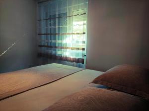 sypialnia z łóżkiem i oknem z zasłonami w obiekcie B&B Onyx w mieście Sisak