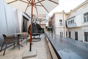 a balcony with a table and chairs and an umbrella at Wall Street Maestro in Odesa