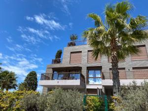 un edificio con una palmera delante de él en Las Lomas Denia I Les Deveses en Denia