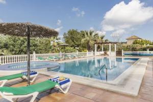einen Pool mit Stühlen und einem Sonnenschirm in der Unterkunft La Manga Club Resort - Individual Villa 439 in Atamaría