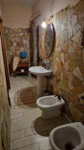 uma casa de banho com um lavatório, um WC e um espelho. em Tenuta Oliva em Fisciano
