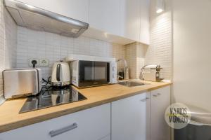 a kitchen with a sink and a microwave at New Loft 1hab 3px en plena Plaza de Chueca in Madrid
