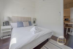a bedroom with a large white bed with blue pillows at New Loft 1hab 3px en plena Plaza de Chueca in Madrid