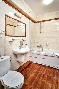 La salle de bains est pourvue de toilettes, d'un lavabo et d'une baignoire. dans l'établissement Hotel Stara Poczta, à Tychy