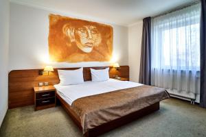 a bedroom with a bed with a lion painting on the wall at Hotel Stara Poczta in Tychy