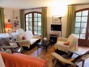 a living room with couches and chairs and a television at La Palmyre - MAISON INDIVIDUELLE - PARC de la RESIDENCE - WIFI in Les Mathes