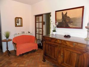un salon avec une chaise orange et une peinture de cheval dans l'établissement La Palmyre - MAISON INDIVIDUELLE - PARC de la RESIDENCE - WIFI, aux Mathes