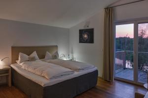 1 dormitorio con 1 cama grande y balcón en Landgut Stober, en Groß Behnitz