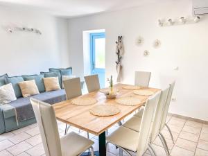 a dining room with a wooden table and chairs at Eco Sunshine Apartments Lumbarda in Lumbarda