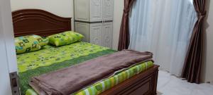 1 dormitorio con 1 cama con sábanas y almohadas verdes en Vila Anggur Pintukabun, en Bukittinggi