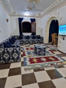 a living room with a couch and a checkerboard floor at Mountain House in Luxor