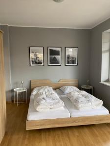 a bed in a bedroom with three pictures on the wall at Seehaus Plön in Plön